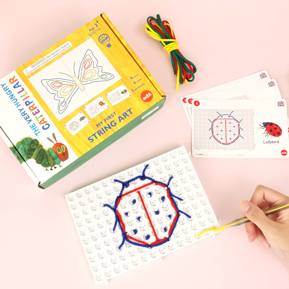 The Very Hungry Caterpillar 'My First String Art' craft kit with a butterfly design box, colorful string, pattern cards, and a child’s hand creating a ladybird design on a pegboard.