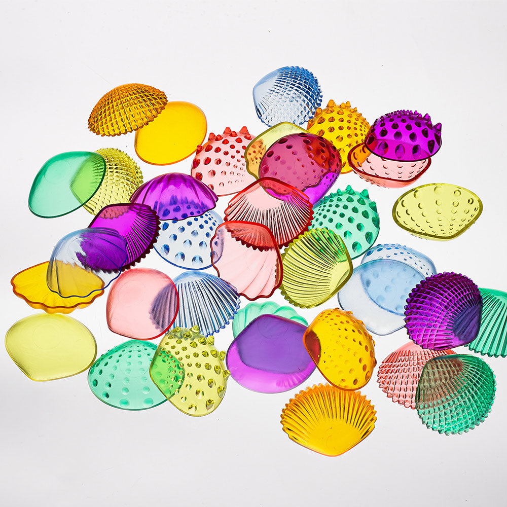Assorted colorful transparent tactile shells from Edx Education, featuring a variety of textures and colors, designed for sensory play and learning activities.