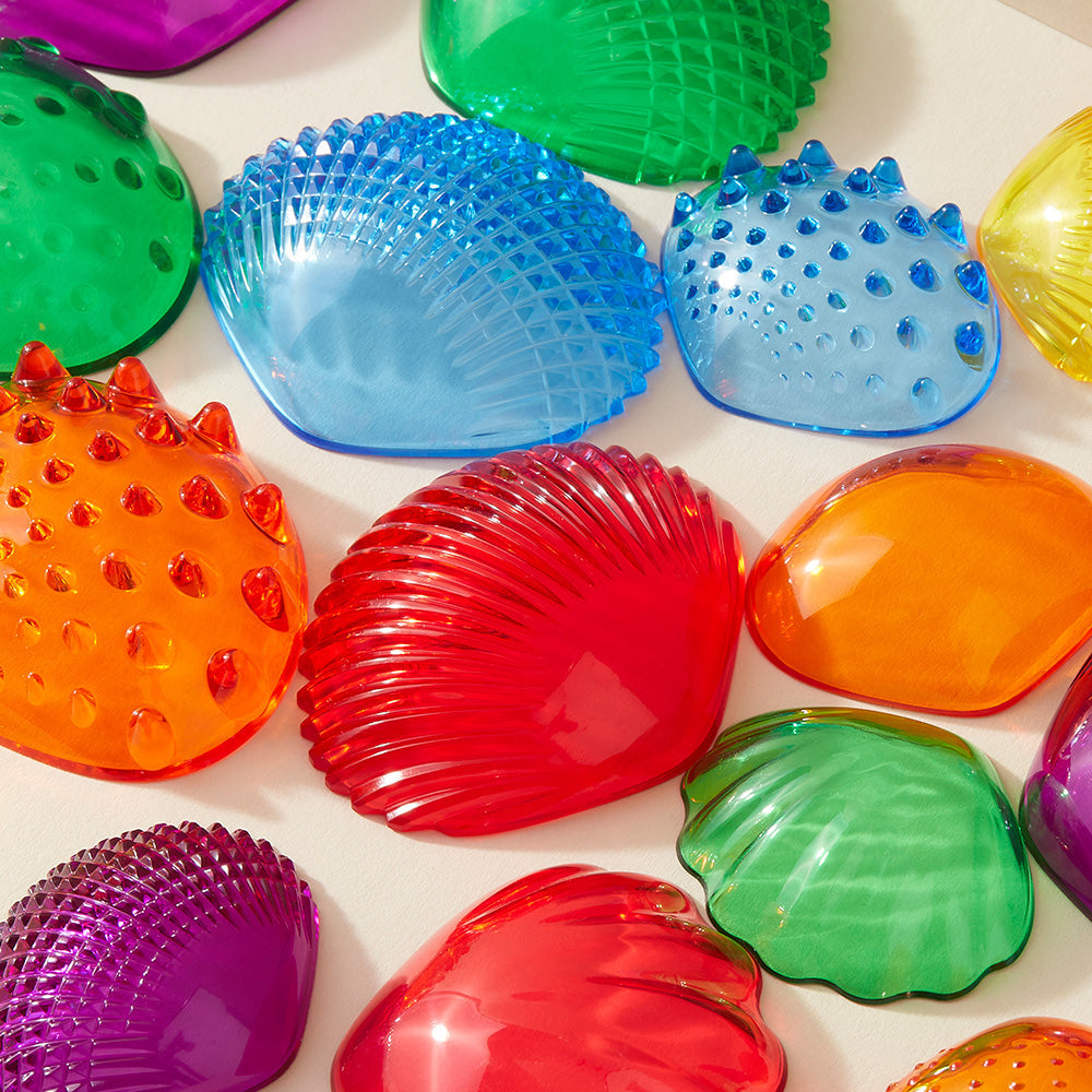 Close-up view of colorful transparent tactile shells by Edx Education, showing a variety of surface textures designed to help children explore both color and touch.