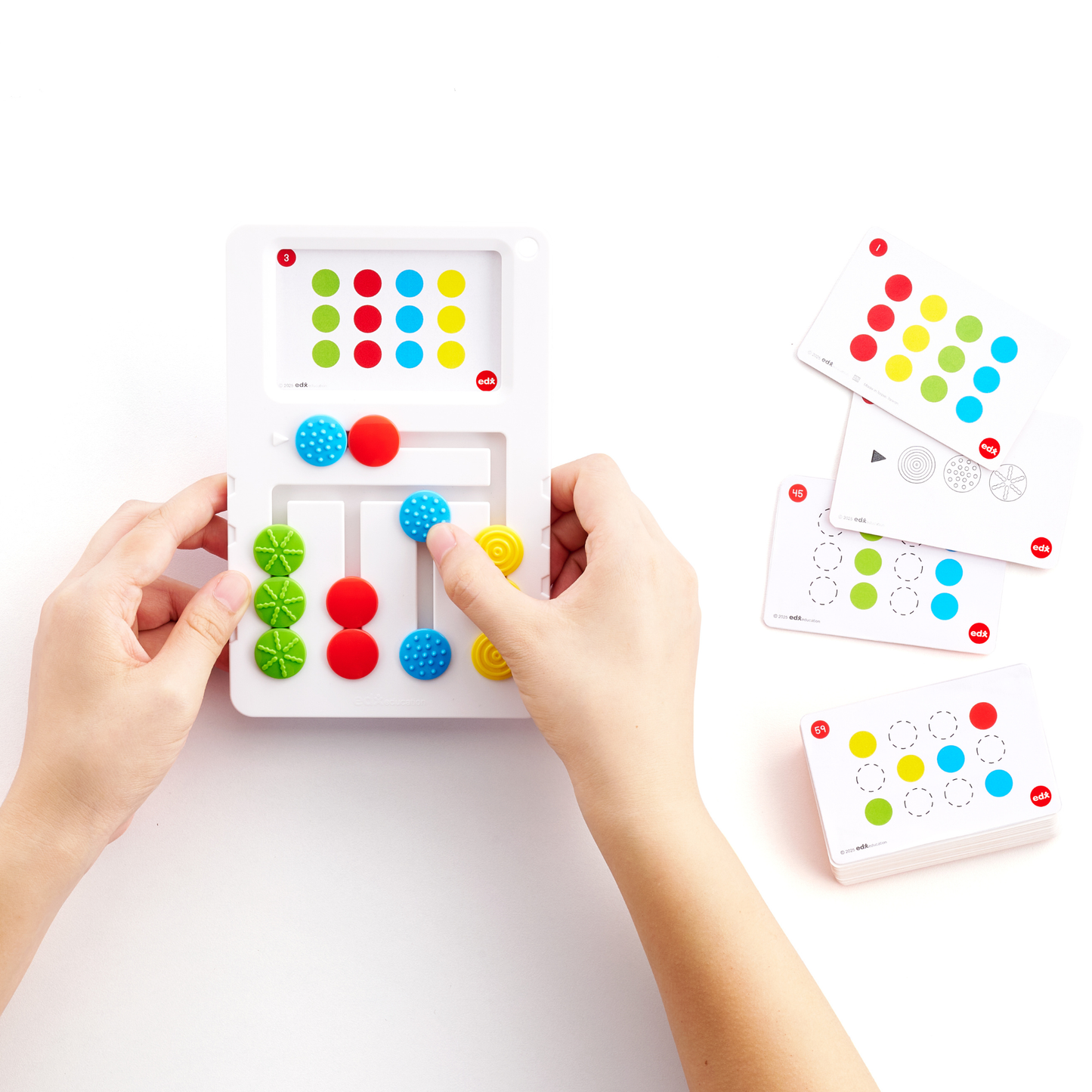 Edx Education Busy Play sensory sliding puzzle showing hands solving a tactile logic game with activity cards for developing fine motor skills and problem-solving